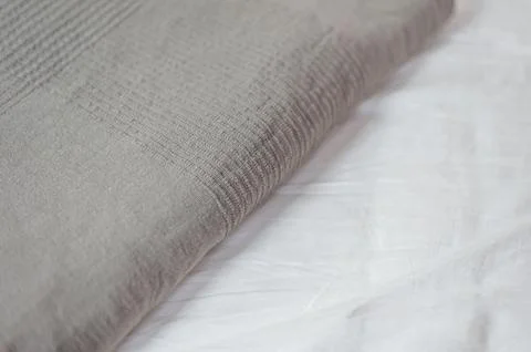 Home textiles. A stack of towels lies on a white bed Stock Photos