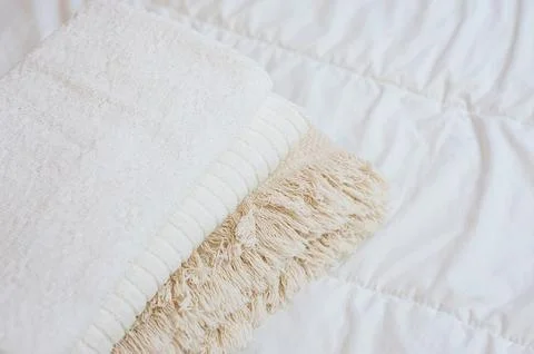 Home textiles. A stack of towels lies on a white bed Stock Photos