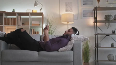 Home video call relaxed guy in headphones on couch Stock Footage 201743666