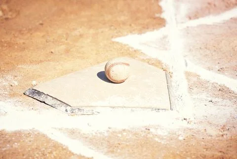 Home is where the base is. a baseball lying on a field during a match. Stock Photos