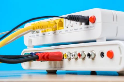 Home wireless router with ethernet cables plugged in on blue background, cl.. Stock Photos