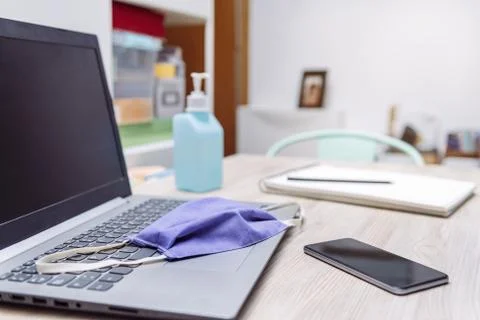 Home work space with protective mask over computer Stock Photos