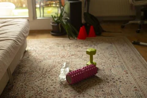 Home workout props on patterned living room rug near sofa Stock Photos