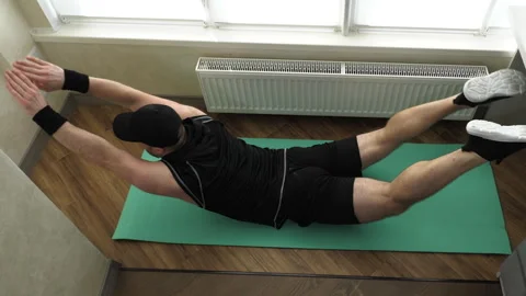 Home workout. Stretch your back muscles while lying on the floor. Exercise Stock Footage 292720649