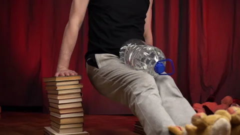 Home Workout.Man performs dips using two stacks of books. Stock Footage 131095859