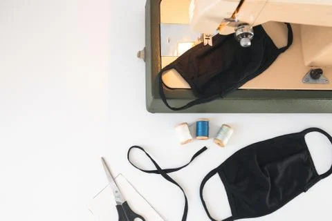 Home workplace with sewing machine,  threads, protective mask on white back Stock Photos