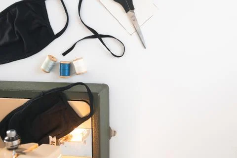 Home workplace with sewing machine,  threads, protective mask on white back Stock Photos