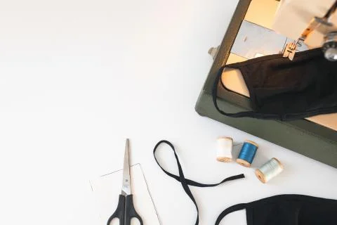 Home workplace with sewing machine,  threads, protective mask on white back Stock Photos