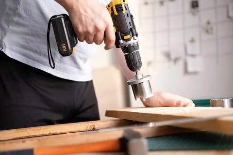 Home workshop. Close-up of a man in goggles working with a drill. Foto stock