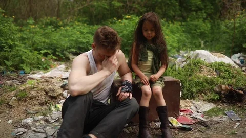 A homeless are sitting on garbage dump in despair and sadness. Vidéo 110993532