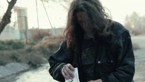 A homeless beggar found the paper document (chance) near the river 스톡 동영상 75837060