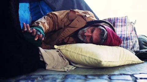 Homeless beggar man lying outdoors in a tent in city. Slow motion. Stock Footage