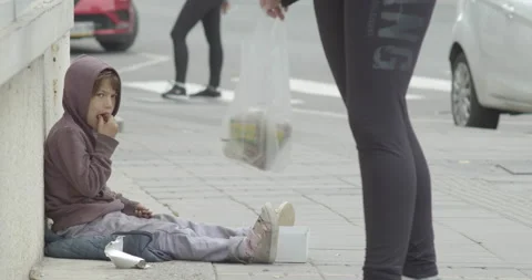 Homeless beggar poor child eating  chocolate, begging on public place Stock Footage