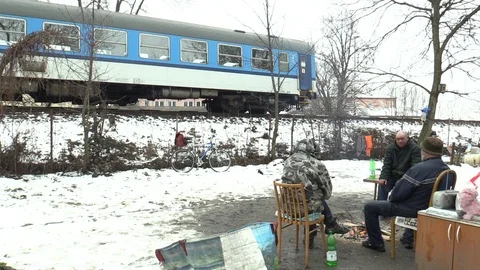 Homeless burning fire to warm themselves in the winter snow, departing train Video stock 86436558