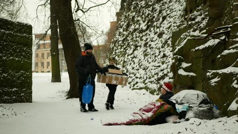 Homeless charity worker help helping park winter snow frost senior volunteers Stock Footage 148285571