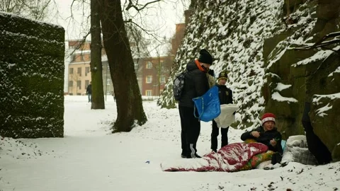 Homeless charity worker help helping park winter snow frost food volunteers Stock Footage 148455568