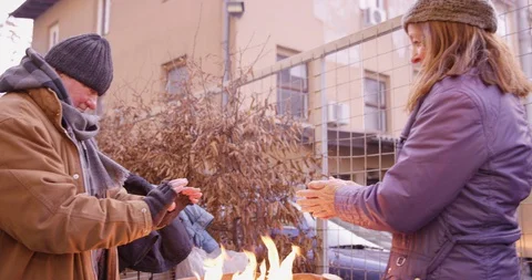 Homeless Couple Standing Next To Fire In A Barrel Stock Footage 128773074