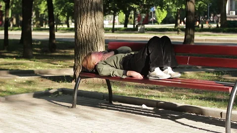 Homeless drunk woman lying on a bench in... | Stock Video | Pond5