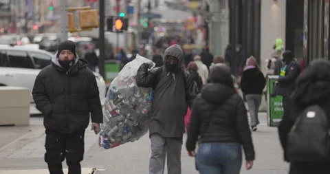 Homeless man carrying empty cans for recycle walking street in New York City Stock Footage 149354800