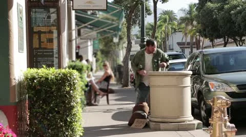 Homeless Man Digging through Trash in a Wealthy District - Model Released Stock Footage 11896345