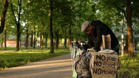 Homeless man looking for something in his trolley. Stock-Footage 76212227