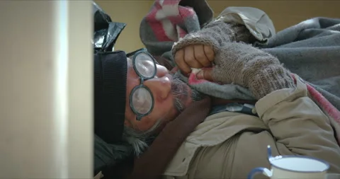 Homeless man is lying down on the sidewalk and asking for money Stock Footage 139847362