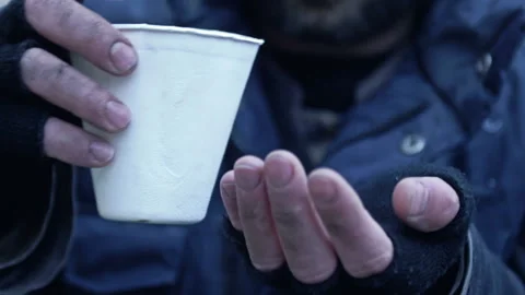 Homeless man shivering in the cold counts the coins collected from handouts. Stock Footage 225501893