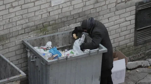 Homeless Man Sifting Through The Trash Looking For Food Stock Footage 254797751
