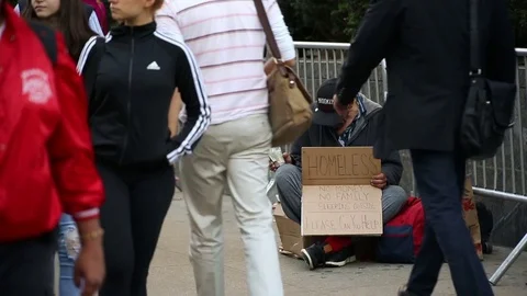 Homeless man with sign asking for help on crowded street people walking NYC Stock Footage 81056847