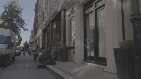 Homeless man sitting on a step outside on a london street Stock Footage 88951094