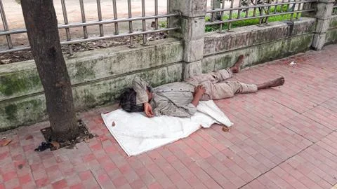 Homeless man sleeping roadside Stock Photos