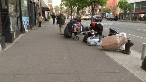 Homeless man sorting bottles cans on street for recycling 6th Ave Manhattan NYC Видео 107342824