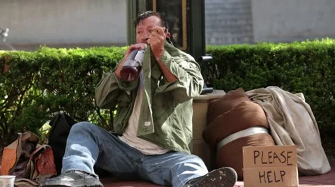 Homeless Man Taking a Drink from a Bottle on the Street - Model Released Stock Footage 11917936