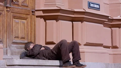 A homeless man warms himself in Riga Dome Square, Latvia. Stock Footage 309553695