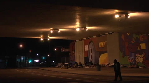 Homeless people living under a bridge at night in the city Stock Footage