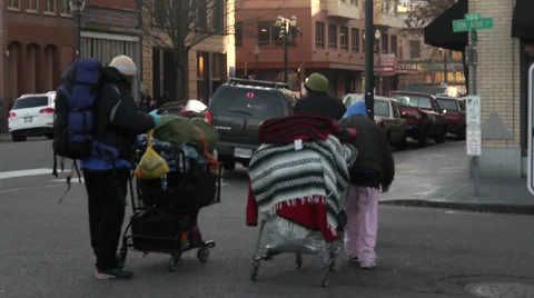 Homeless people pushing carts in street downtown Stock Footage