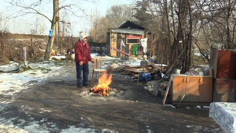 Homeless poor burning and creating fire to warm themselves in the winter snow Video stock 85902368