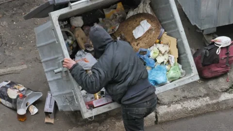 Homeless, Poor man rummaging through garbage bin in search of something to eat. 스톡 동영상 121481691