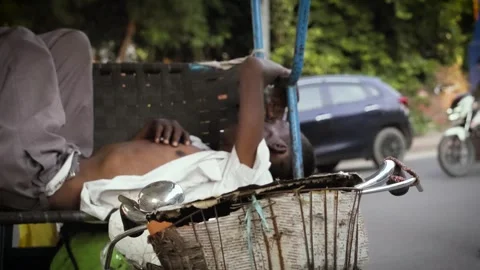 Homeless Poor Man Sleeping on Cycle Rickshaw on Indian Street, Delhi Road Stock-Footage 316893018