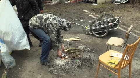 Homeless poor prepares ignites burning wood branch cracked and creating fire Stock Footage 88271868