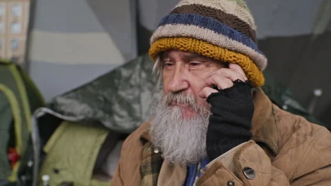 Homeless Senior Man Talking on Mobile Phone in Tent Encampment Stock Footage 345715691