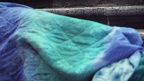 Homeless sleeping while someone wake him leaving coin Stock Footage 74720728