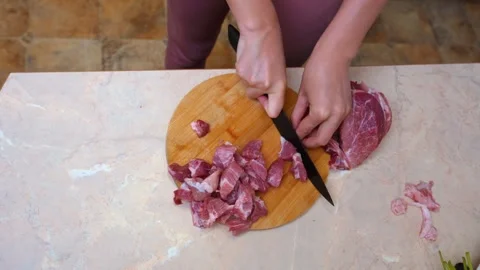 Homely kitchen setting with someone preparing bitesized meat portions Stock Footage 328494314