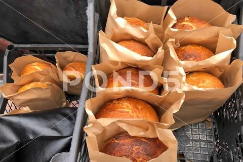 Homemade baked bread in paper packaging, bakery products of private businessmen Stock Photos