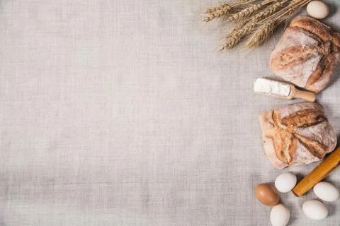 Homemade bread, eggs, flour, rolling pin and ears of wheat Stock Photos