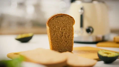 Homemade bread slice positioned next to a toaster on a kitchen counter Stock Footage 323864902