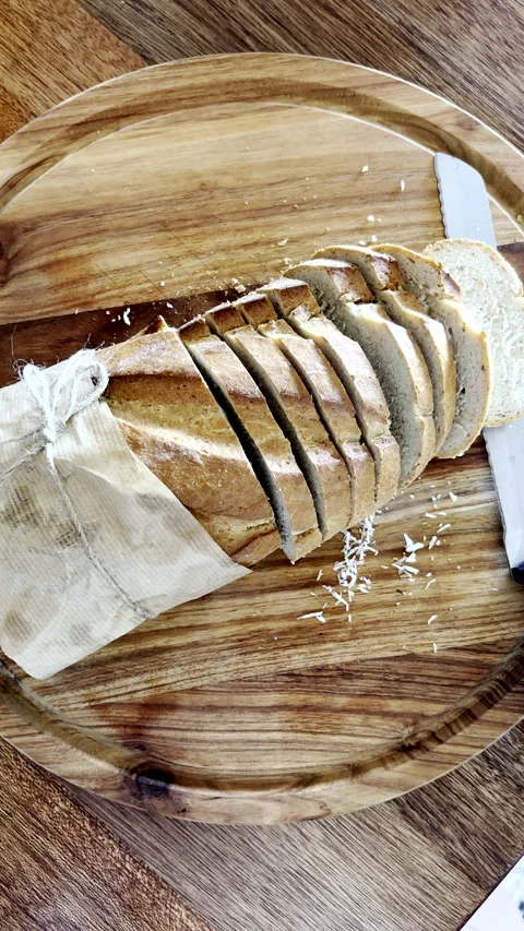 Homemade bread with slices and knife on wooden cutting board Stock Footage 343397100
