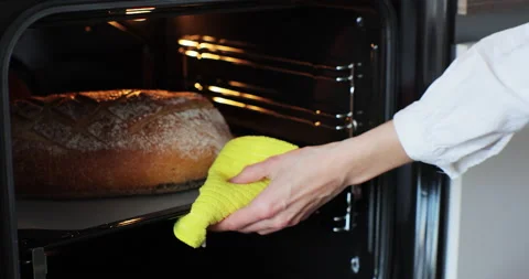 Homemade bread taking off from the oven. Making bread at home. Bread baking. Stock Footage 239557640