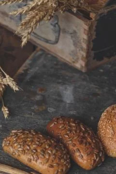 Homemade bread with wheat ears on rustic wooden background. Stock Photos