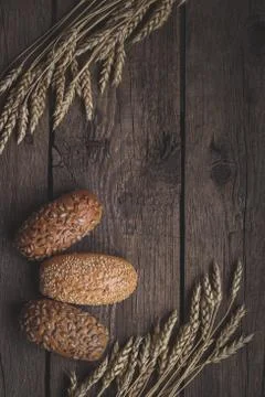Homemade bread with wheat ears on rustic wooden table. Stock Photos
